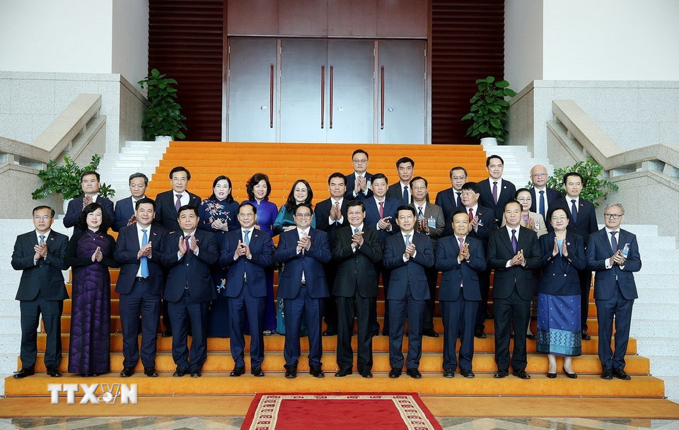 Thủ tướng Phạm Minh Chính và Tổng Bí thư, Chủ tịch nước Lào Thongloun Sisoulith với thành viên đoàn hai nước. (Ảnh: Dương Giang/TTXVN)