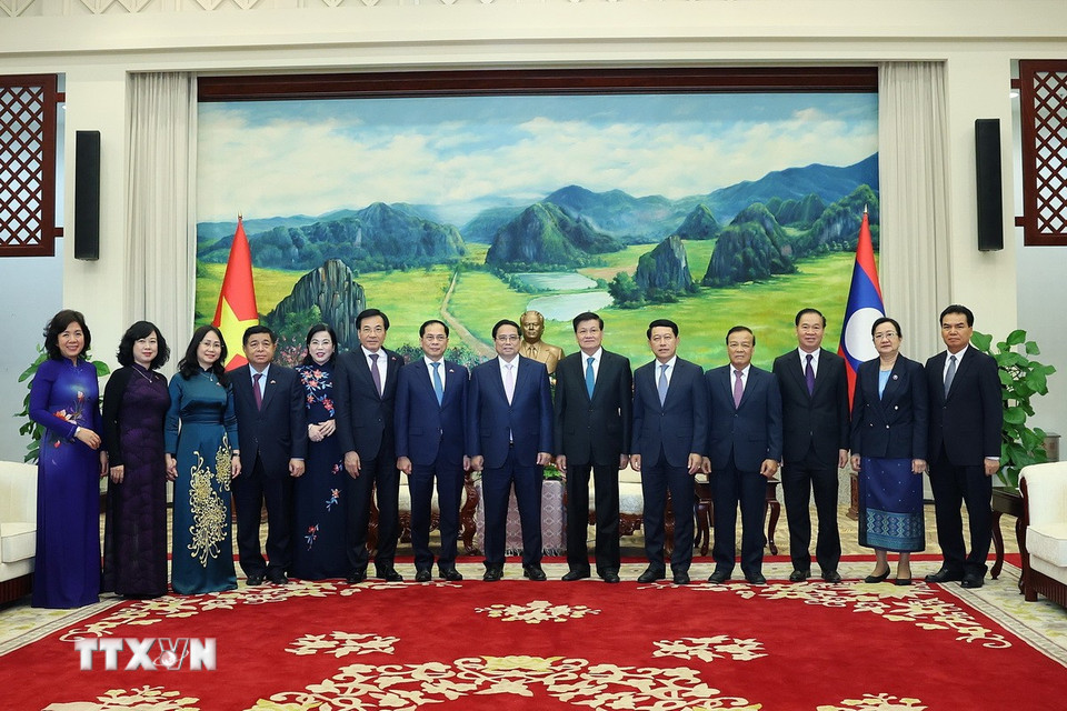 Thủ tướng Phạm Minh Chính và Tổng Bí thư, Chủ tịch nước Lào Thongloun Sisoulith với thành viên đoàn hai nước. (Ảnh: Dương Giang/TTXVN)