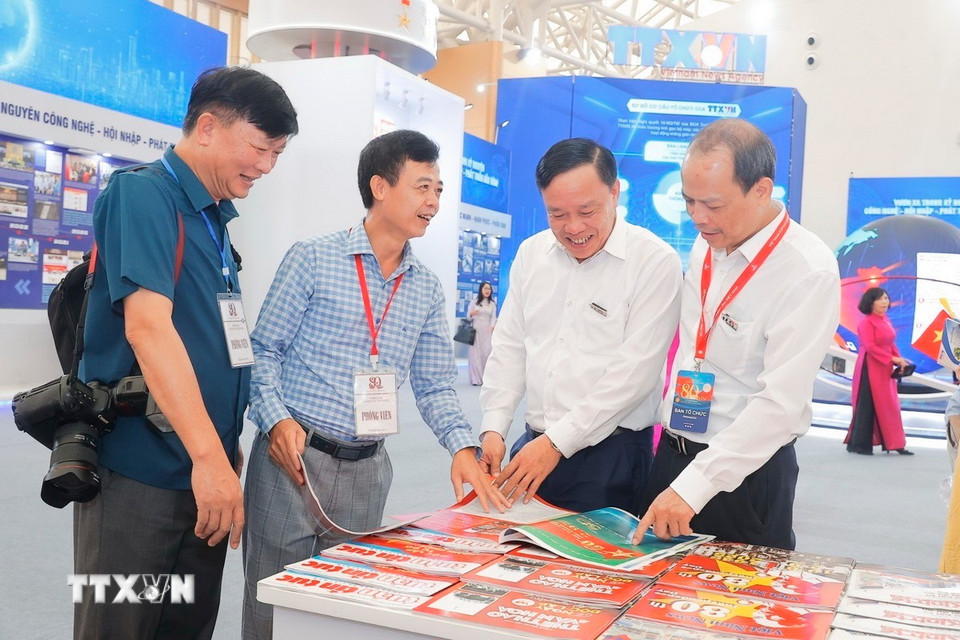 Các đại biểu xem các ấn phẩm tại Gian trưng bày của TTXVN. (Ảnh: Minh Quyết/TTXVN)