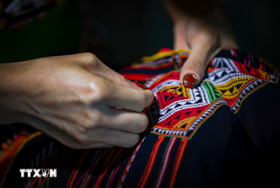 Thêu các họa tiết hoa văn trên chiếc khăn Piêu. (Ảnh: Xuân Tư/TTXVN)