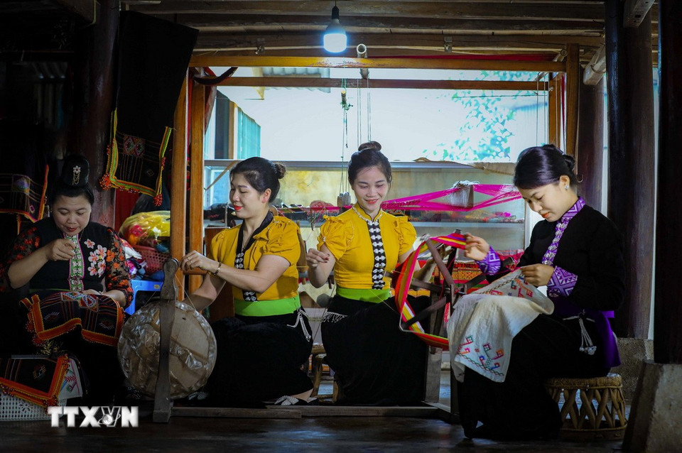 Những phụ nữ dân tộc Thái thêu trang phục dân tộc. (Ảnh: Xuân Tư/TTXVN)