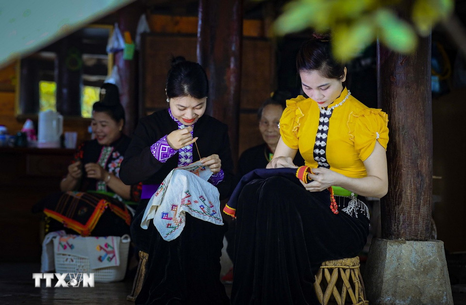 Thiếu nữ dân tộc Thái thêu trang phục truyền thống. (Ảnh: Xuân Tư/TTXVN)