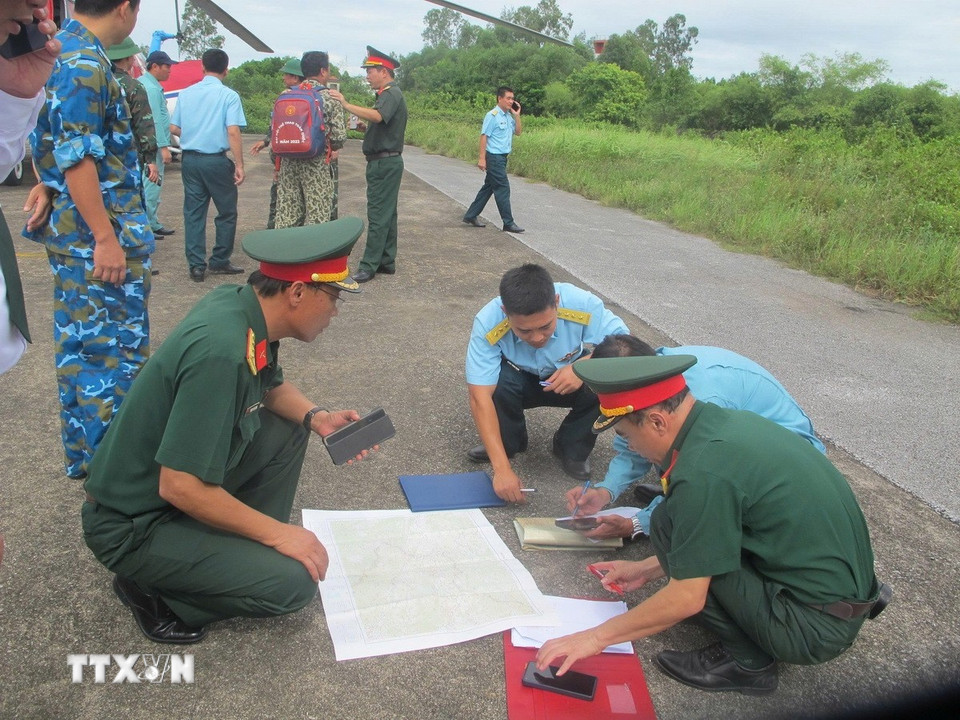 Các cán bộ, chiến sỹ bàn phương án tác chiến đi vào vùng lũ tỉnh Nghệ An. (Ảnh: TTXVN phát)