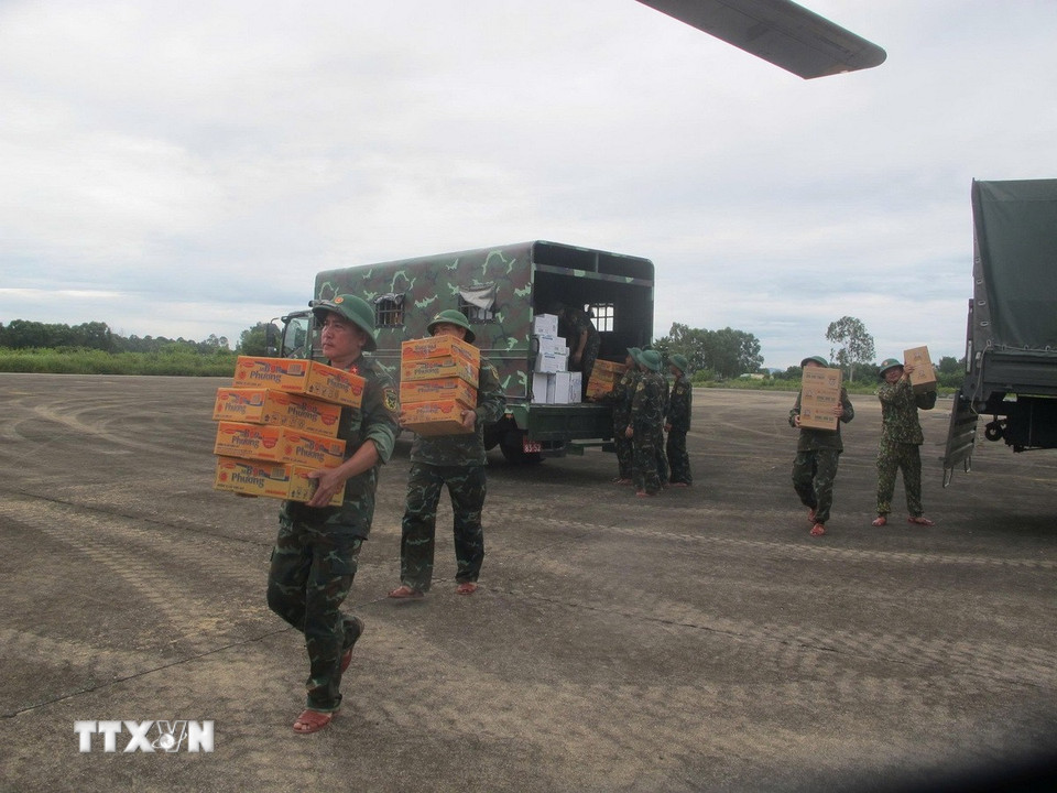 Các cán bộ, chiến sỹ vận chuyển nhu yếu phẩm cần thiết lên trực thăng để đi cứu trợ người dân vùng lũ Nghệ An. (Ảnh: TTXVN phát)