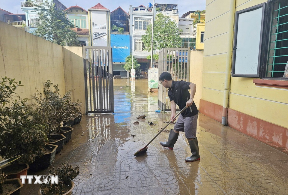 Người dân phường Phan Đình Phùng dọn vệ sinh nhà của ngay khi nước lũ rút. (Ảnh: Hoàng Nguyên/TTXVN)