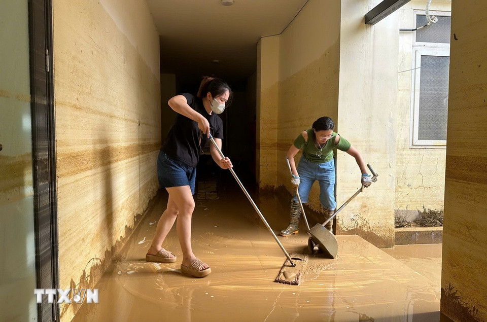 Người dân phường Phan Đình Phùng dọn vệ sinh nhà của ngay khi nước lũ rút. (Ảnh: Hoàng Nguyên/TTXVN)