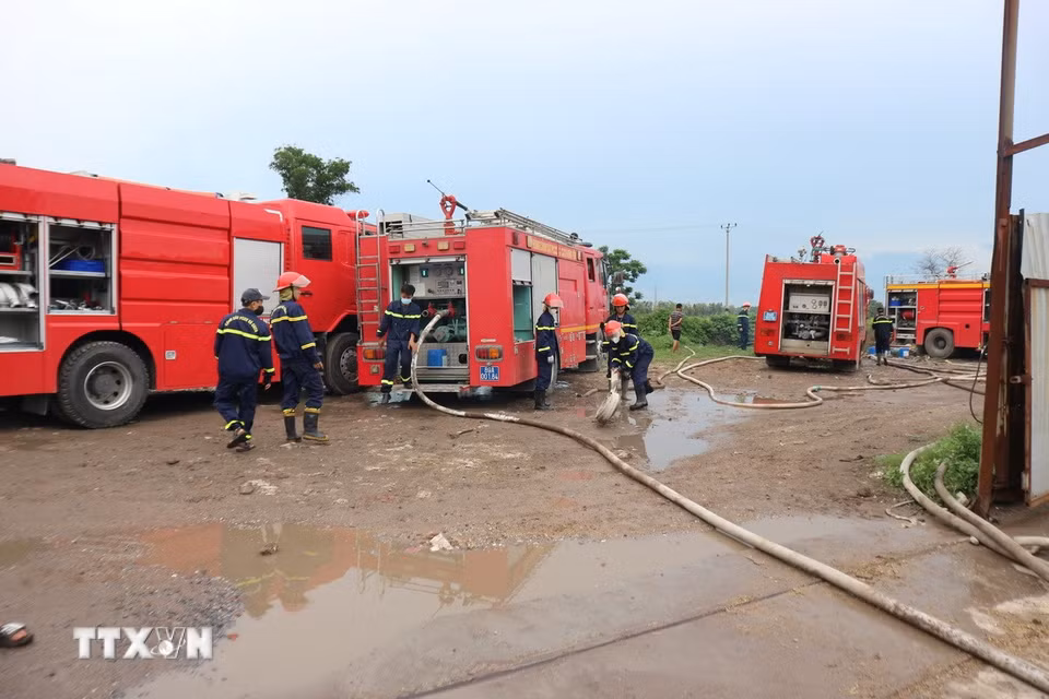 Lực lượng chức năng điều động nhiều phương tiện dập lửa. (Ảnh Mạnh Khánh/TTXVN)