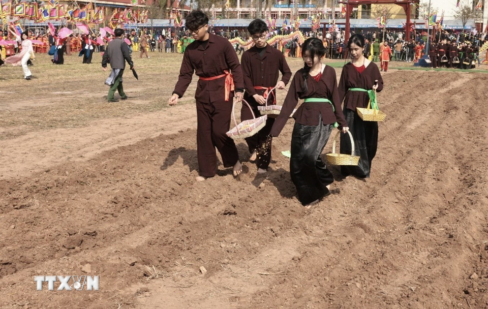 Các nam thanh, nữ tú với nghi thức rắc hạt. (Ảnh: Trần Việt/TTXVN)