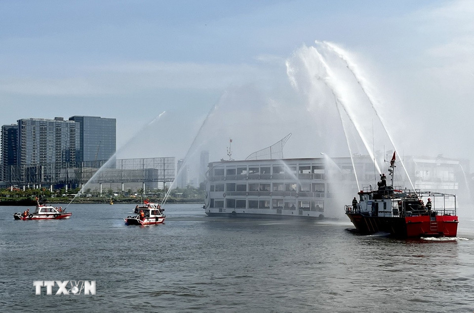 Lực lượng phối hợp xử lý tình huống khẩn cấp, chữa cháy, cứu nạn, cứu hộ tàu trên sông Sài Gòn. (Ảnh: Thanh Vũ/TTXVN)