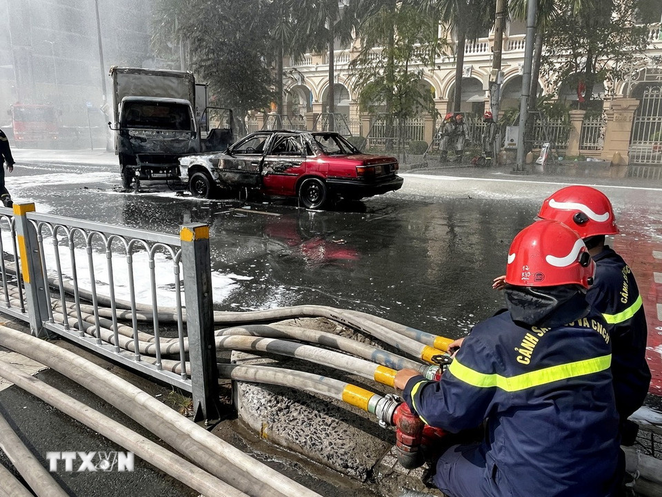 Lực lượng phối hợp xử lý tình huống khẩn cấp chữa cháy, cứu nạn, cứu hộ tại hiện trường giả định vụ cháy hai xe ôtô. (Ảnh: Thanh Vũ/TTXVN)