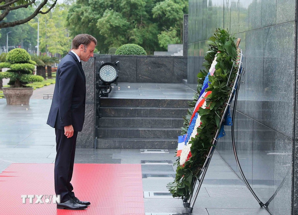 Tổng thống Pháp Emmanuel Macron đặt vòng hoa và kính cẩn tưởng niệm Chủ tịch Hồ Chí Minh. (Ảnh: An Đăng/TTXVN)