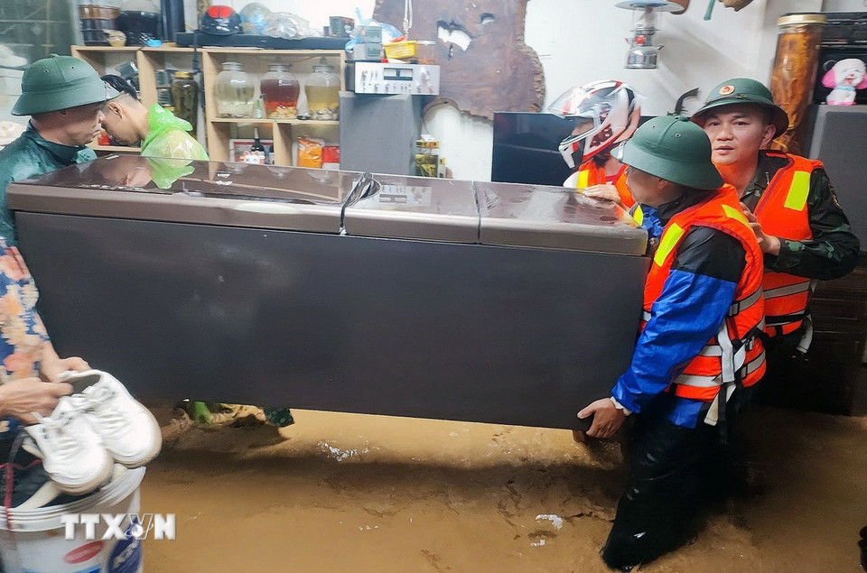 Di dời tài sản cho nhân dân trong khu vực bị ngập lụt. (Ảnh: TTXVN phát)