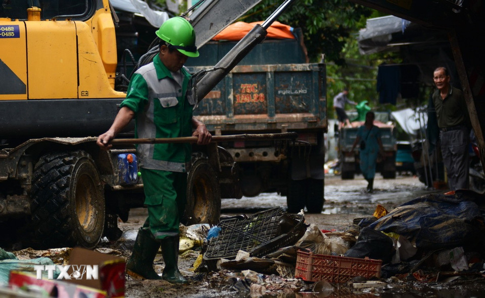 Anh Hoàng Toàn cho biết đợt lũ này phát sinh lượng rác lớn, nên buộc phải tăng ca, làm ngày đêm với mong muốn sớm trả lại môi trường sạch đẹp. (Ảnh: Văn Dũng/TTXVN)