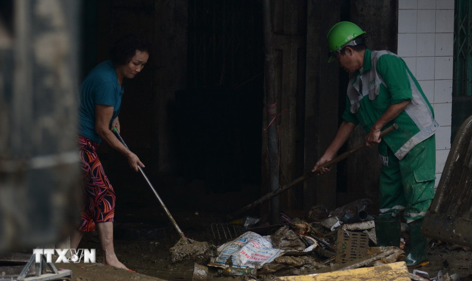 Trong quá trình dọn rác, công nhân của Công ty cổ phần Môi trường và Công trình đô thị Huế cũng nhận được sự giúp đỡ của người dân. (Ảnh: Văn Dũng/TTXVN)