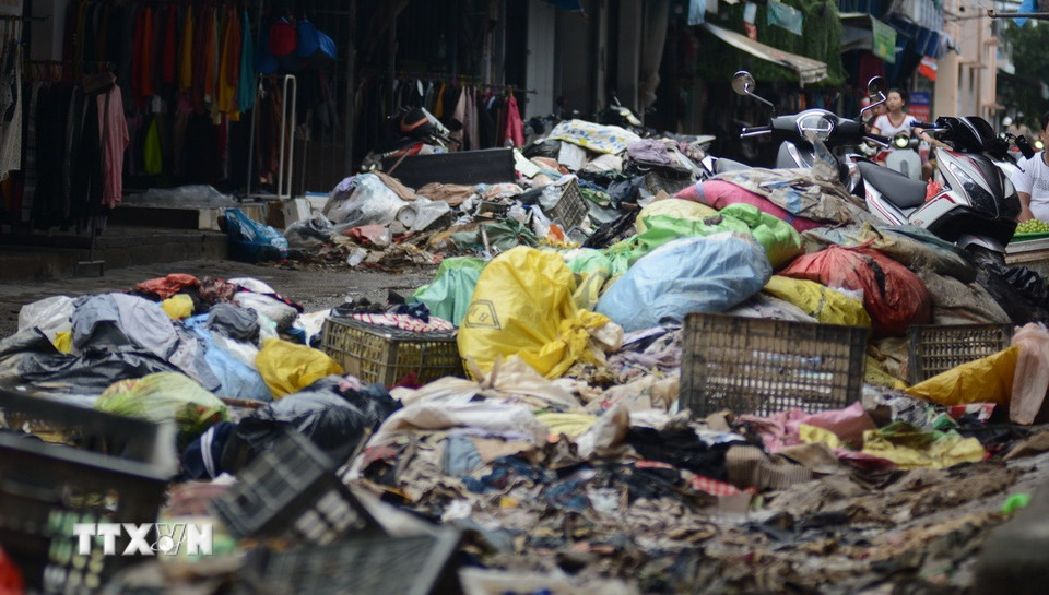 Sau ngập lụt, nhiều vật dụng gia đình, hàng hóa cửa hàng chìm trong nước và bị hư hỏng, phải vứt bỏ. Đây cũng là nguyên nhân phát sinh ra nhiều loại rác thải. (Ảnh: Văn Dũng/TTXVN)