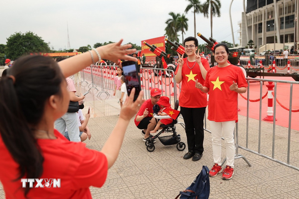 Người dân hào hứng lưu lại những bức ảnh kỷ niệm cùng dàn pháo lễ tại Sân vận động Mỹ Đình. (Ảnh: Vũ Quang/TTXVN)