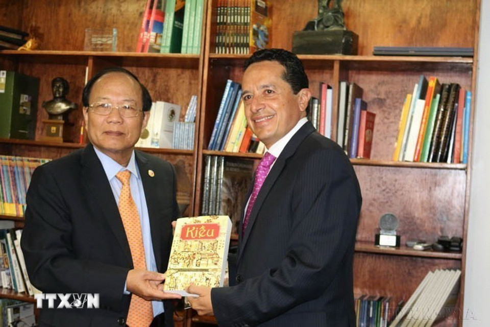 Bộ trưởng Bộ Văn hóa, Thể thao và Du lịch Hoàng Tuấn Anh trao tặng tác phẩm truyện Kiều cho Thứ trưởng Du lịch Mexico Carlos Joaquin (Mexico, 16/8/2015). (Ảnh: Việt Hòa/TTXVN)