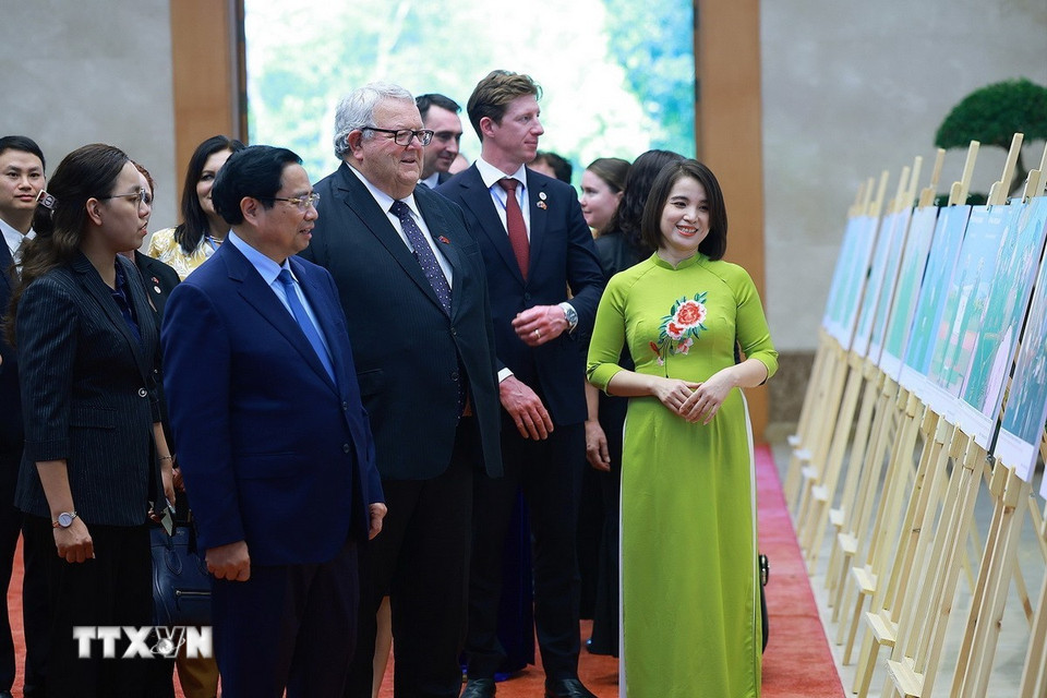 Thủ tướng Phạm Minh Chính và Chủ tịch Quốc hội New Zealand Gerry Brownlee tham quan trưng bày ảnh về quan hệ hợp tác giữa hai nước do TTXVN thực hiện. (Ảnh: Dương Giang/TTXVN)