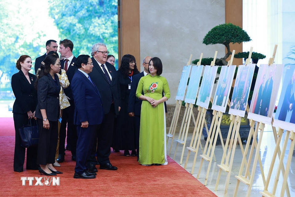 Thủ tướng Phạm Minh Chính và Chủ tịch Quốc hội New Zealand Gerry Brownlee tham quan trưng bày ảnh về quan hệ hợp tác giữa hai nước do TTXVN thực hiện. (Ảnh: Dương Giang/TTXVN)