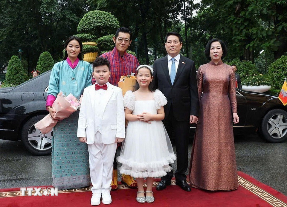 Chủ tịch nước Lương Cường và Phu nhân cùng Quốc vương Bhutan Jigme Khesar Namgyel Wangchuck và Hoàng hậu với thiếu nhi Thủ đô Hà Nội tại lễ đón. (Ảnh: Lâm Khánh/TTXVN)
