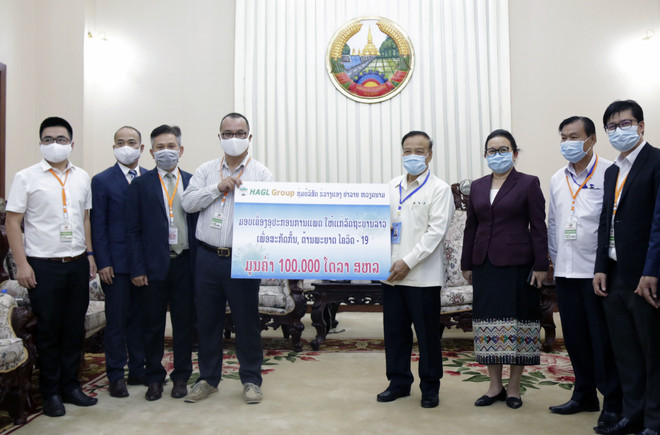 Ông Chế Quang Long, Trưởng đại diện Tập đoàn Hoàng Anh Gia Lai tại Lào (trái) đang trao tượng trưng số tiền 100.000 USD cho Phó Thủ tướng Lào Somdy Duangdy. (Ảnh: Phạm KiênVietnam+) Tập đoàn Hoàng Anh Gia Lai tặng Lào thiết bị y tế chống dịch COVID-19 ảnh 1