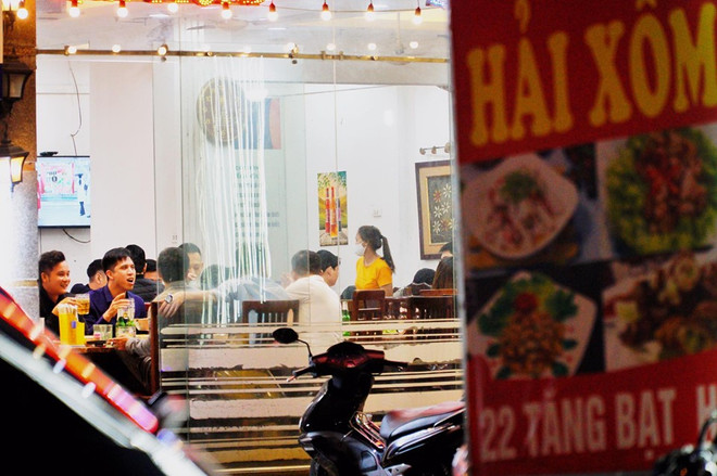 Tại quán bia trên đường Tăng Bạt Hổ, những vị khách dường như đã quên hết mối nguy cơ mang tên COVID-19. (Ảnh: Minh Hiếu/Vietnam+) Hà Nội: Không đeo khẩu trang, vô tư uống bia trong quán đông nghẹt ảnh 2