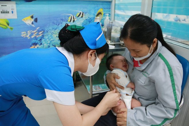 Bé gái 2 tháng tuổi tiêm vaccine 6 trong 1 tại Bệnh viện Nhi đồng Đồng Nai. (Ảnh: Lê Xuân/TTXVN) ttxvn-bach hau2.jpg