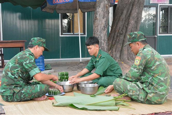 Các chiến sỹ biên phòng tại Chốt kiểm soát biên giới, Đồn Biên phòng Ia Rvê, Bộ đội Biên phòng Đắk Lắk, gói bánh chưng cùng nhau đón Tết nơi biên cương. (Ảnh: Tuấn Anh/TTXVN) Những người lính biên phòng “chắc tay súng” đón Tết ở vùng biên ảnh 1