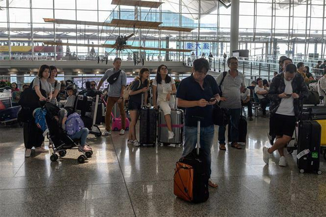 Hành khách tại sân bay quốc tế Hong Kong ngày 14/8. (Ảnh: AFP/TTXVN) Hong Kong công bố gói hỗ trợ kinh tế trị giá hơn 2 tỷ USD ảnh 1