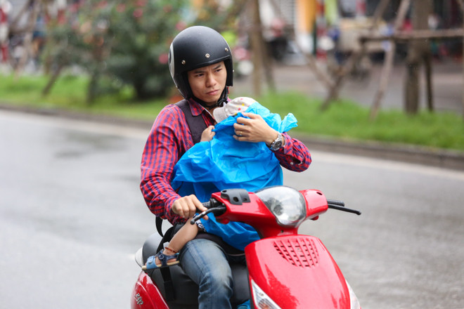 [Photo]: Người dân Hà Nội co ro lạnh khi thời tiết đã sang Hè ảnh 1