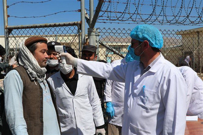 Nhân viên y tế kiểm tra thân nhiệt nhằm ngăn dịch COVID-19 tại Dushi, tỉnh Baghlan, Afghanistan. (Ảnh: THX/TTXVN) Khẩu trang hay thực phẩm - Lựa chọn khó khăn với người nghèo tại Nam Á ảnh 1