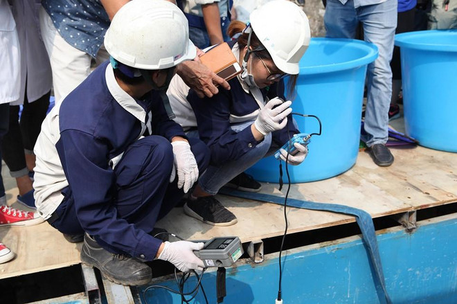 Lấy mẫu nước tại hiện trường. (Ảnh: Sơn Bách/Vietnam+) Hà Nội: Thả cá Koi Nhật Bản xuống sông Tô Lịch và Hồ Tây ảnh 7