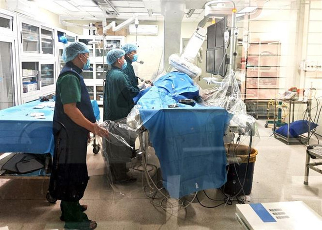 Bác sỹ khoa Tim mạch tiến hành đặt stent 1 mạch vành nhánh phải cho bệnh nhân người nước ngoài. (Ảnh: TTXVN phát) Hà Giang: Cứu sống bệnh nhân Quốc tịch Canada bị nhồi máu cơ tim cấp ảnh 1