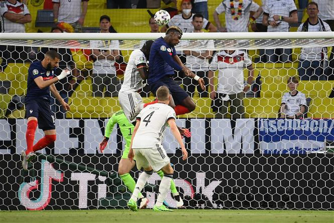Tiền đạo Pháp Paul Pogba (phải) đánh đầu về phía khung thành tuyển Đức trong trận đấu tại vòng chung kết EURO 2020 ở Munich (Đức) ngày 15/6. (Ảnh: AFP/TTXVN) EURO 2020: Chiến bại của đội tuyển Đức hay của Joachim Loew? ảnh 1