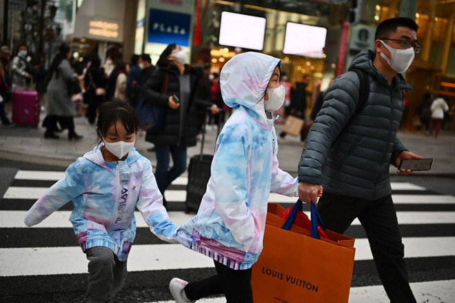 Người đi bộ đeo khẩu trang bảo vệ ở Tokyo. (Nguồn: Getty Images) Dịch viêm phổi: Thêm ca nhiễm mới tại Nhật Bản và Singapore ảnh 1
