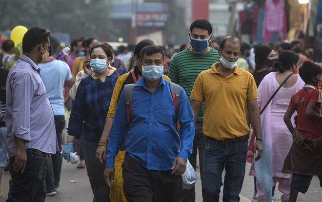 Người dân đeo khẩu trang phòng lây nhiễm COVID-19 tại New Delhi, Ấn Độ. (Ảnh: THX/TTXVN) Làn sóng người lao động di cư rời khỏi các thành phố ở Ấn Độ ảnh 1