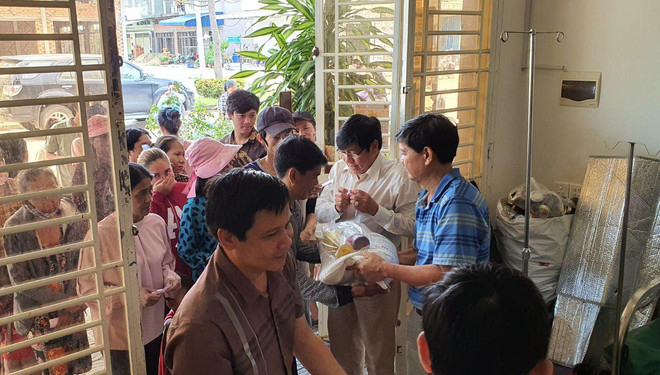 Tổng Lãnh sự Vũ Ngọc Lý (áo xanh) cùng đoàn công tác trao đồ cứu trợ cho bà con gốc Việt tại Kampong Speu. (Ảnh: Trần Long/Vietnam+) Khẩn cấp cứu trợ hàng trăm người gốc Việt bị lũ lụt tại Campuchia ảnh 1