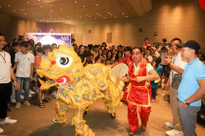 Màn múa Lân cùng với chị Hằng và chú Cuội khuấy động không khí của Lễ hội. (Ảnh: Lê Dương/TTXVN) Trung Thu của người Việt ở Singapore: Nhiều hoạt động truyền thống ảnh 1