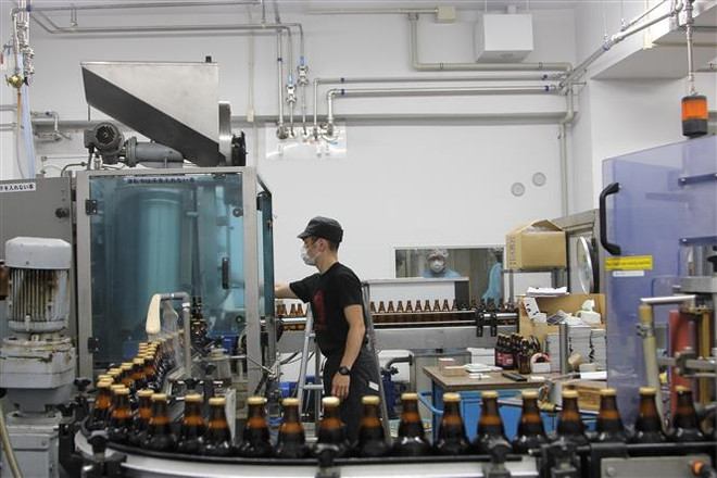 Dây chuyền sản xuất tại nhà máy bia ở Nhật Bản. (Ảnh: Đào Thanh Tùng/TTXVN) Những tín hiệu bấp bênh về sự phục hồi của nền kinh tế toàn cầu ảnh 1