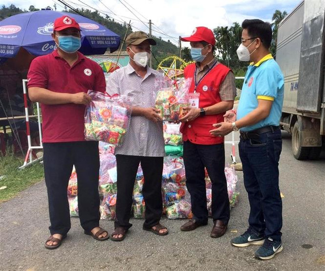 Ban tổ chức trao quà cho đại diện người dân xã Trà Phong. (Ảnh: Lê Ngọc Phước/TTXVN) Quảng Ngãi tặng quà Trung Thu cho trẻ em tại khu vực phong tỏa ảnh 1