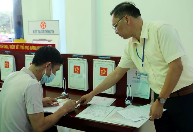 Cán bộ của Sở Giao thông vận tải tỉnh Lai Châu hướng dẫn người dân cách kê khai các thủ tục cần thiết để làm các loại giấy tờ liên quan. (Ảnh: Quý Trung/TTXVN) ttxvn_cai_cach_thu_tuc_hanh_chinh_1.jpg