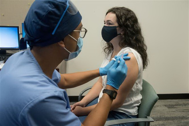 Tiêm thử nghiệm vắcxin ngừa COVID-19 cho tình nguyện viên. (Ảnh: AFP/TTXVN) GSK và Sanofi bắt đầu thử nghiệm lâm sàng vắcxin phòng COVID-19 ảnh 1