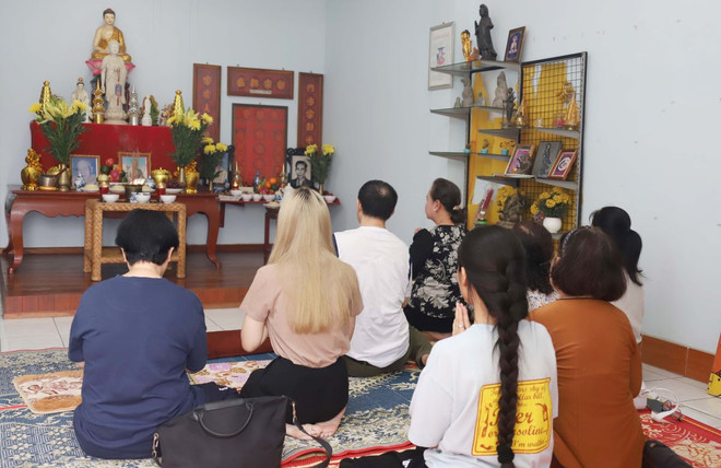Bà Trần Thị Tuyết Anh cùng con cháu thực hiện nghi thức cúng gia tiên trong ngày Lễ Vu Lan tại Lào. (Ảnh: Xuân Tú/TTXVN) ttxvn-vu lan3.jpg
