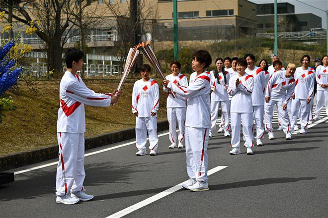 Các vận động viên tham gia lễ rước đuốc Olympic Tokyo 2020, tại Naraha, tỉnh Fukushima, Nhật Bản. (Ảnh: AFP/TTXVN) Nhật Bản huy động gần 60.000 sỹ quan bảo đảm an ninh cho Olympic ảnh 1