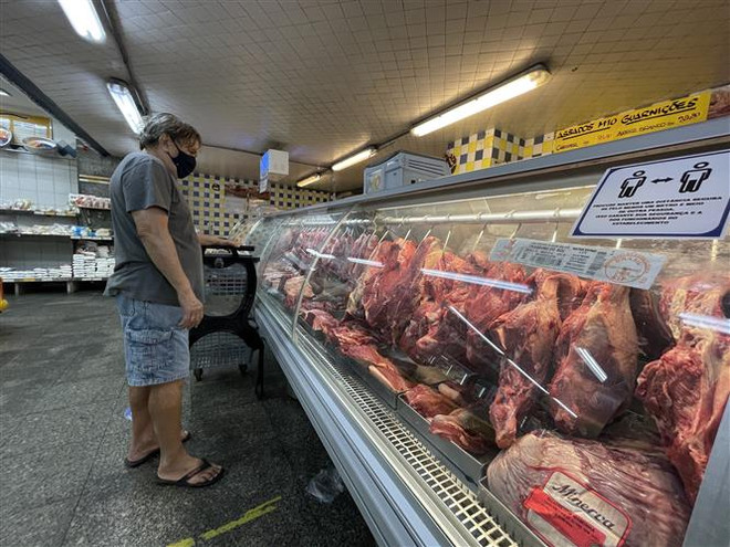 Người dân mua thực phẩm tại cửa hàng ở Rio de Janeiro, Brazil. (Ảnh: AFP/TTXVN) S&P Global hạ dự báo tăng trưởng của các nền kinh tế mới nổi ảnh 1