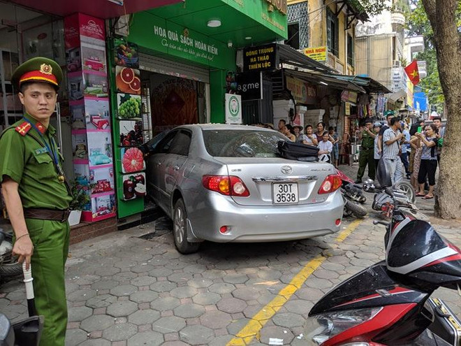 Hiện trường vụ việc (Ảnh: Vietnam+) Đang di chuyển, ôtô 'nổi điên' lao thẳng vào cửa hàng bán hoa quả ảnh 2