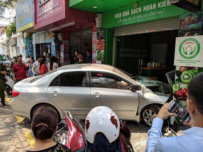 Hiện trường vụ việc (Ảnh: Vietnam+) Đang di chuyển, ôtô 'nổi điên' lao thẳng vào cửa hàng bán hoa quả ảnh 1