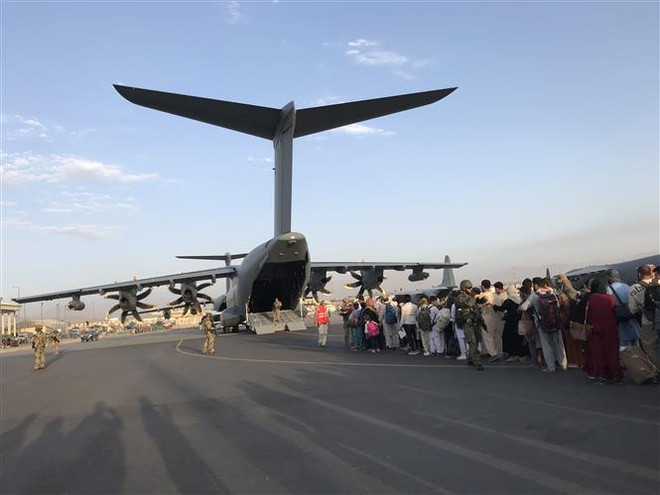 Người dân xếp hàng chờ lên máy bay quân sự Đức để rời Afghanistan tại sân bay Kabul, ngày 24/8. (Ảnh: THX/TTXVN) Những kỷ lục ấn tượng nhất trong năm theo đánh giá của AFP ảnh 3