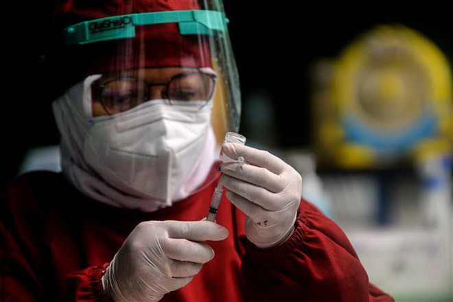 Nhân viên tế chuẩn bị mũi tiêm vaccine ngừa COVID-19 tại Tangerang, Indonesia. (Ảnh: THX/TTXVN) Indonesia đặt mục tiêu tiêm vaccine cho 208 triệu dân để đạt miễn dịch ảnh 2