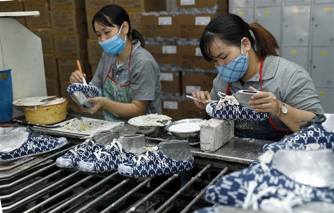Sản xuất giày xuất khẩu tại Công ty Trách nhiệm hữu hạn Hóa dệt Hà Tây. (Ảnh: Trần Việt/TTXVN) Ngân hàng Thế giới đánh giá kinh tế Việt Nam vẫn duy trì đà phục hồi ảnh 1